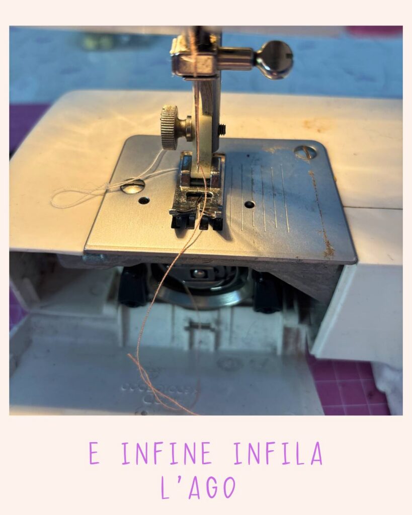 Vista ravvicinata dell’ago della macchina da cucire con il filo infilato dal lato frontale