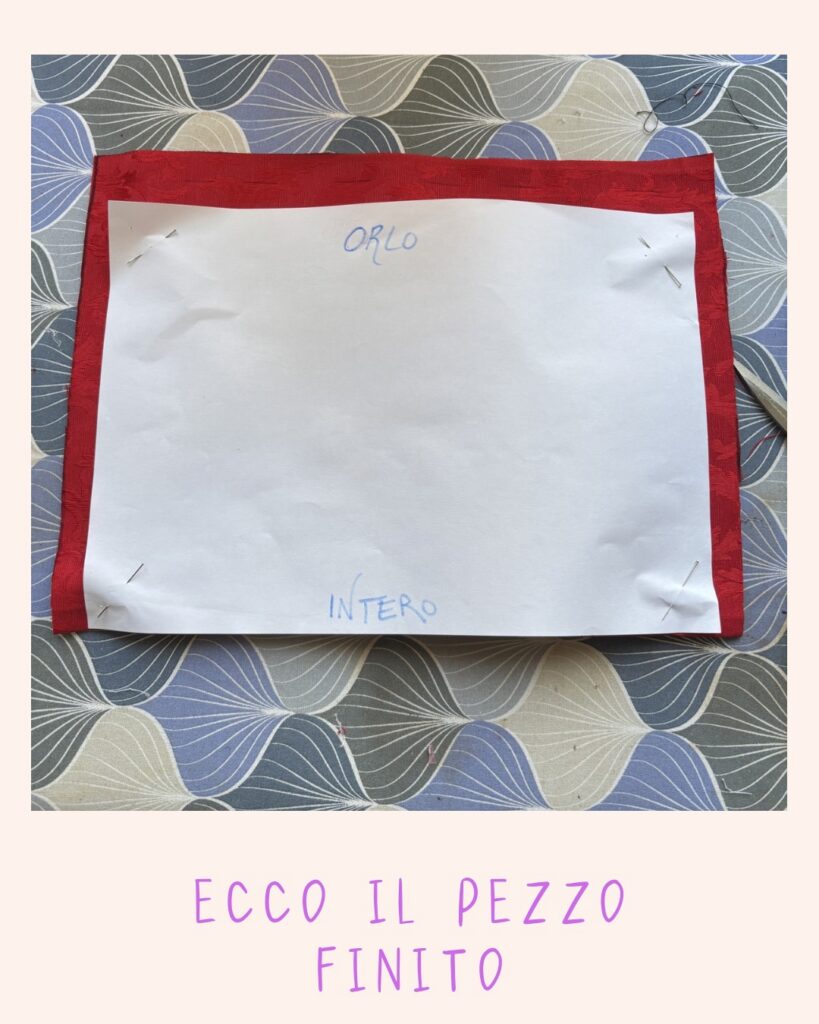 Pezzo di tessuto rosso ritagliato con cartamodello spillato