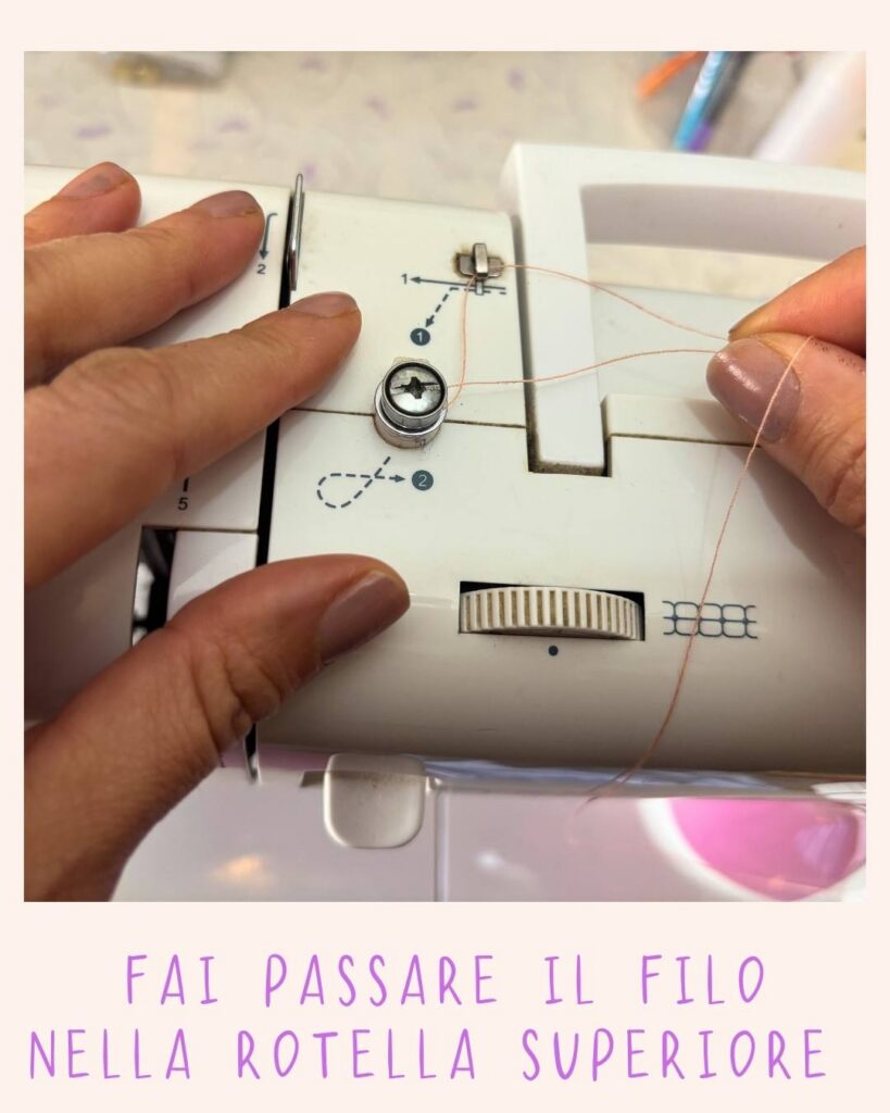 Mani che guidano il filo attraverso la rotella superiore di una macchina da cucire