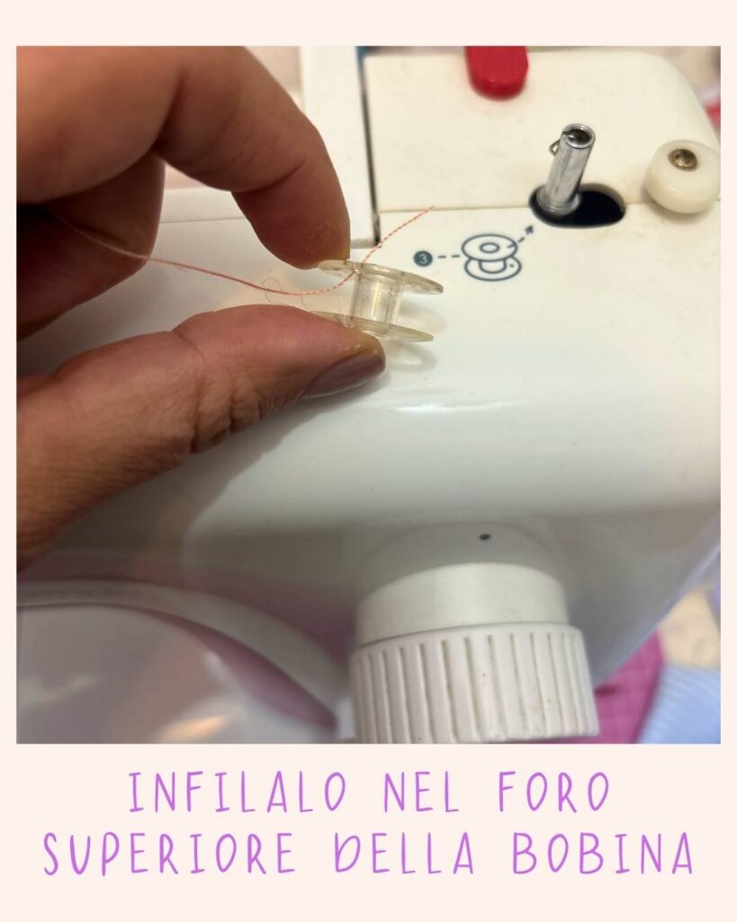 Mano che tiene una bobina trasparente con il filo inserito nel foro superiore