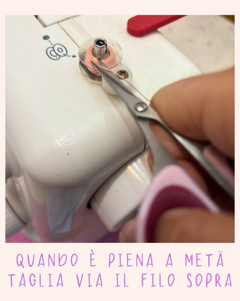 Forbicine che tagliano il filo sopra la bobina a metà riempimento